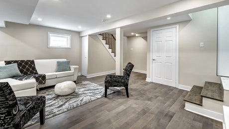 Modern basement living area with dark vinyl plank flooring and neutral décor.